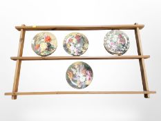 A pine plate rack, width 104 cm, and eleven Wedgwood floral collector's plates.