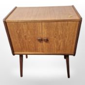 A 20th century teak double door record storage cabinet on tapering legs, 61 cm x 37 cm x 74 cm.