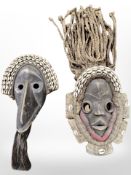 Two Ivory Coast carved hardwood dance masks, decorated with sea shells.