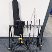 A group of guitar and other instrument stands, instrument case,