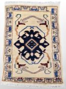 An Afghan/Caucasian rug, 94 cm x 64 cm.