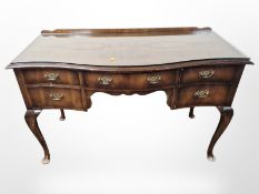 A walnut serpentine front five drawer side table, with plate glass top, 120 cm x 50 cm x 76 cm.