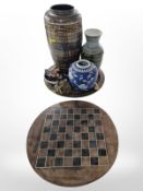 An Eastern enameled brass charger, chess board and carved stone pieces,