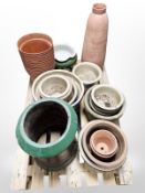 A palette of concrete and ceramic planters, chimney cap, plastic plant pots, etc.