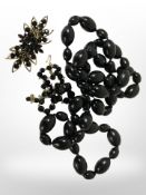 A simulated jet, beadwork necklace, further similar faceted necklace, and a brooch.
