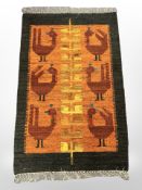 An Eastern flatweave kilim depicting stylised birds upon an orange field, 84 cm x 127 cm.