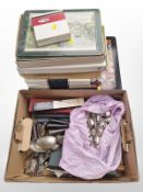 A box of assorted collectors spoons, some silver, further plated cutlery, placemats, coasters, etc.