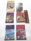 A set of Harry Potter books, wand, VHS cassette, lapel badge.