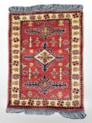 An Afghan/Caucasian rug, 91 cm x 64 cm.