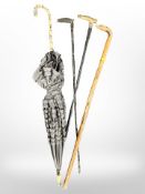 A vintage umbrella, two horn handled walking canes one with silver collar,