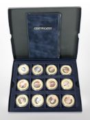 A group of 12 Queen Elizabeth II gold-plated commemorative coins.