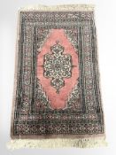 A Lahore Bokhara rug, Pakistan, with an ivory medallion against a salmon field,