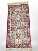 A machine made rug of Central Iranian Ghom design, 114 cm x 57 cm.