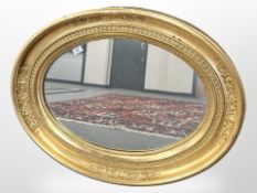 A 19th century oval gilded mirror, 85 cm x 65 cm.