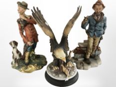 Two Capo Di Monte figures of tramps and a figure of an eagle,