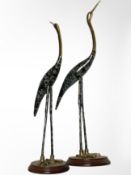 A pair of lacquered brass figures of herons on wooden plinths,