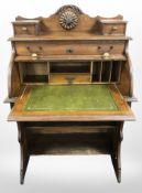An Edwardian Arts & Crafts lady's oak cylinder front bureau,