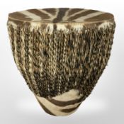 An animal hide upholstered tribal drum, height 45 cm.
