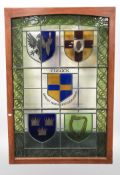 A stained, leaded and painted glass panel depicting the Cusack coat of arms, in wooden frame,