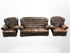 A Chesterfield style chestnut brown leather three piece wingback lounge suite,