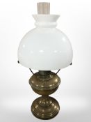 A brass oil lamp with opaque glass shade, height 52 cm.