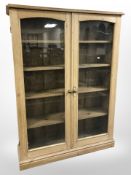 A Victorian glazed pine double door bookcase, 115 cm x 32 cm x 156 cm.
