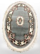 A Chinese oval fringed rug,