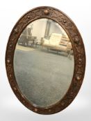 An Edwardian Arts & Crafts oval mirror,