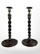 A pair of oak barley twist candlesticks with brass sconces