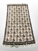 A fringed woolen rug of Eastern design,