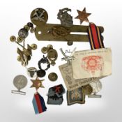 A group of World War I and World War II badges, medals, buttons, clothing book, etc.