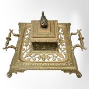 An ornate cast brass desk stand with central ink well,