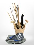 A wicker basket, assorted pool cues, wooden mallets, tennis racket,