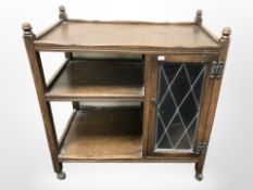 A reproduction oak three tier trolley with leaded glass door, length 73 cm.
