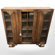 A 1920s glazed oak display cabinet, 121 cm x 30 cm x 121 cm.