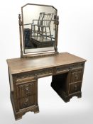 An early 20th century carved oak linen fold dressing table,