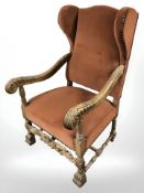 A continental carved oak wingback arm chair on paw feet, width 69 cm.