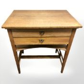 An Arts and Crafts oak two drawer work table, width 69 cm.
