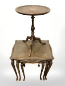 A carved walnut nest of three tables and a yew wood tripod table