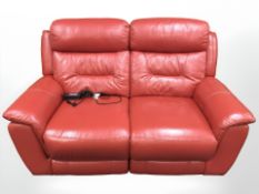 A DFS red leather electric reclining two seater settee,