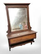 An early 20th century mahogany wall mirror with storage box beneath,