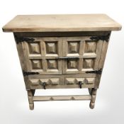 A reproduction beech double door cabinet with wrought iron mounts, 80 cm x 37 cm x 91 cm.