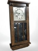 An early 20th century American oak cased wall clock with silvered dial,