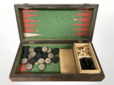 An antique checkers/back gammon board with pieces and a chess set