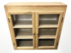 A glazed pine double door cabinet,