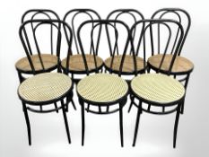 A set of seven ebonised bergere chairs.