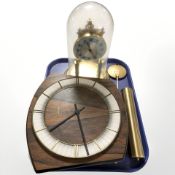 A Junghans wall clock with pendulum and weights and an anniversary clock under dome.