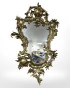 A gilt metal baroque style wall mirror,