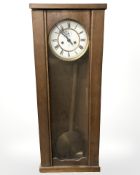 An early 20th century continental oak wall clock with enamelled dial,