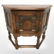 A reproduction carved oak single door side cabinet,